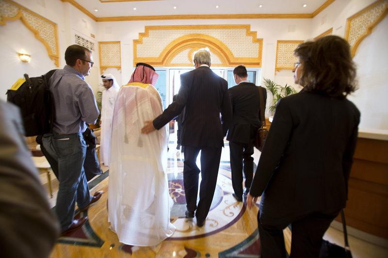 Secretary of State John Kerry walks through the airport after being greeted on arrival in Doha, Qatar, on Saturday for the beginning of peace talks with the Taliban.