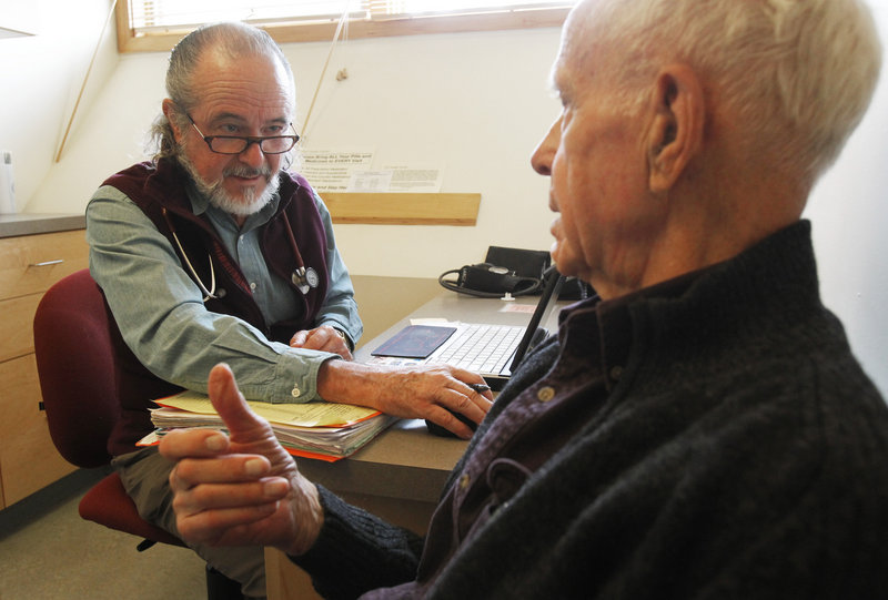 Ronald Pitkin, right, meets with his doctor, John Matthew, in Plainfield, Vt.