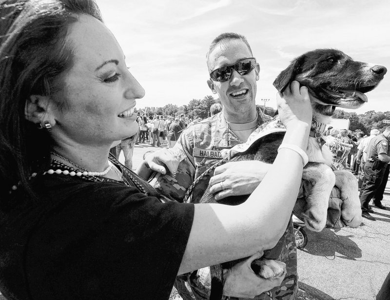 Victoria Halbach, left, and Sgt. Jason Halbach play with their dog Bravo on Jason’s return from Afghanistan.