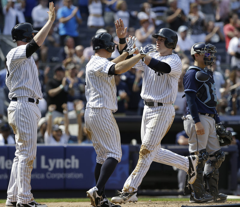 David Adams, right, celebrates with teammate Brett Gardner after scoring on a double by Vernon Wells during the Yankees’ 7-5 win over Tampa Bay.