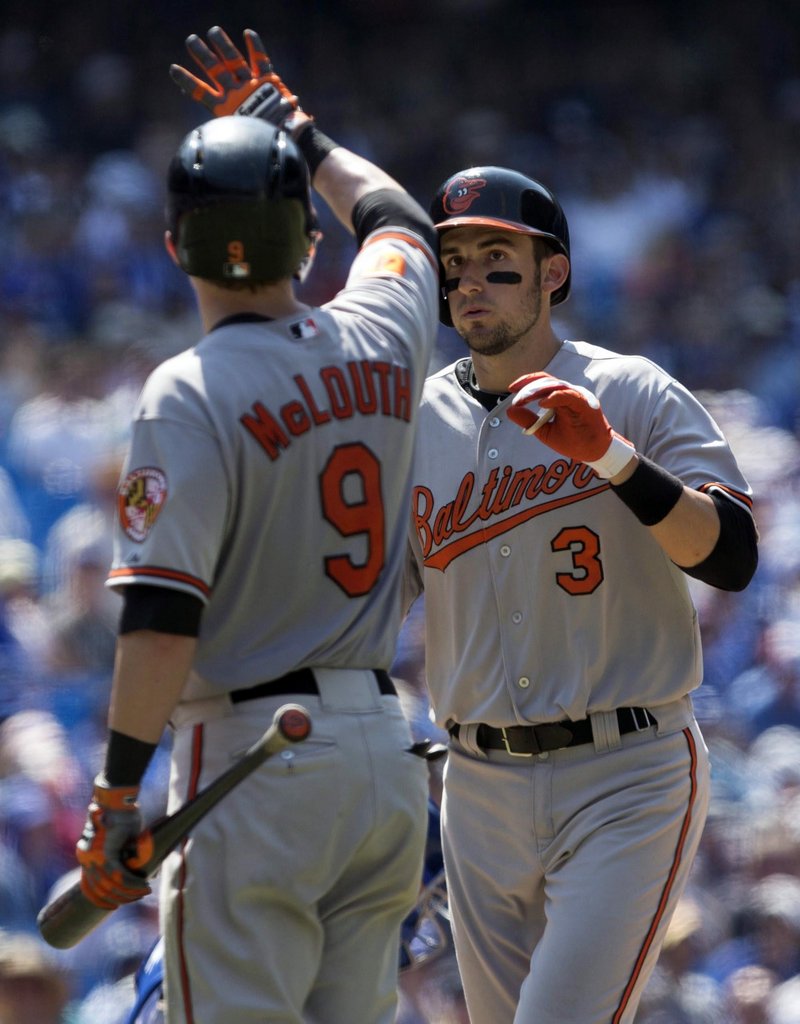 Ryan Flaherty is congratulated by Baltimore teammate Nate McLouth after hitting his second homer of the game in the ninth inning of a 13-5 loss to Toronto.