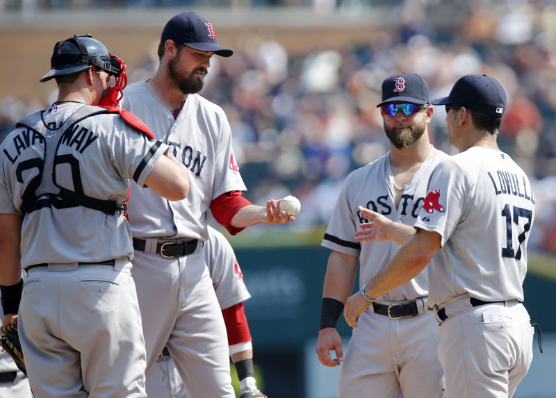 Red Sox reliever Andrew Miller, second from left, is pulled by bench coach Torey Lovullo (17) after loading the bases to start the eighth inning against the Tigers on Sunday. All three runners scored, helping Detroit take a 7-5 win.