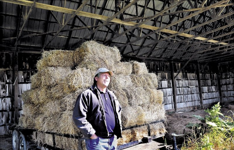Richard Hopper, president of Kennebec Valley Community College, speaks beside a hay wagon in an unused barn at the Alfond campus in Hinckley on Wednesday. The section in one of three barns will be used to store farm equipment. while another section will have labs and classrooms for sustainable farming courses.