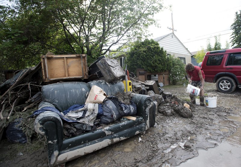 Residents are in flood clean-up mode in Calgary, Alberta, on Monday. Alberta’s premier pledged $1 billion to help people recover from floods that devastated parts of the province.