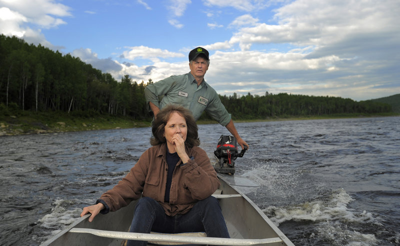 Cathie Pelletier rides on the St. John River in a canoe piloted by her brother, Vernon.