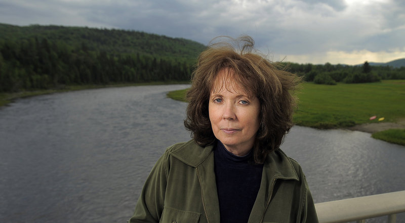 With the Allagash River in the background, Cathie Pelletier poses near her ancestral home in Allagash.