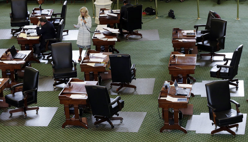 Wendy Davis, D-Fort Worth, stands on a near-empty floor as she filibusters in an effort to kill an abortion bill Tuesday in Austin, Texas. The bill would ban abortion after 20 weeks of pregnancy and force many clinics to close.