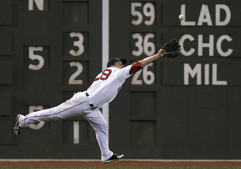 Left fielder Daniel Nava of the Boston Red Sox stretches Tuesday night in a bid to haul in a ball hit by Carlos Gonzalez of the Colorado Rockies in the seventh inning at Fenway Park. The ball dropped in for a single.