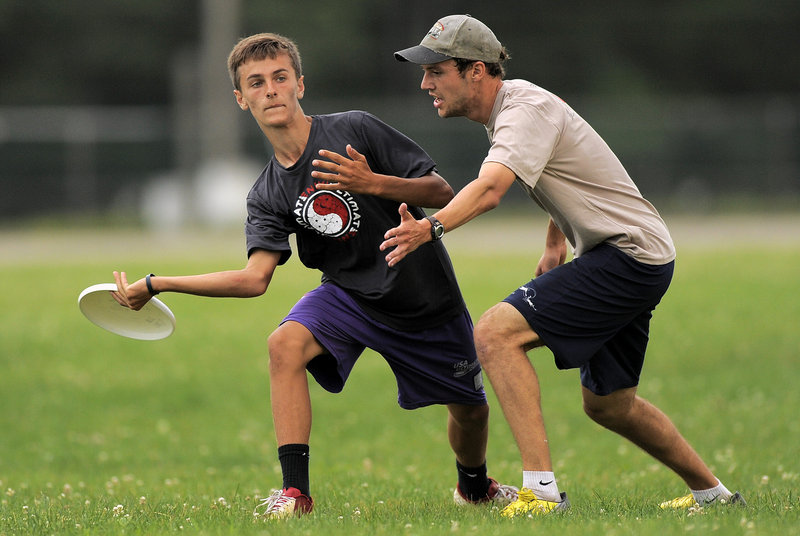 Nick Plummer, a member of Rising Tide, looks to throw around Nate Buck of the New Gloucester Village Store during their game.