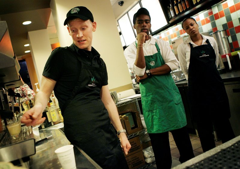 Starbucks employees Tracy Bryant, right, and Roland Smith watch as a manager Justin Chapple demonstrates how to make an espresso at a Starbucks in New York.