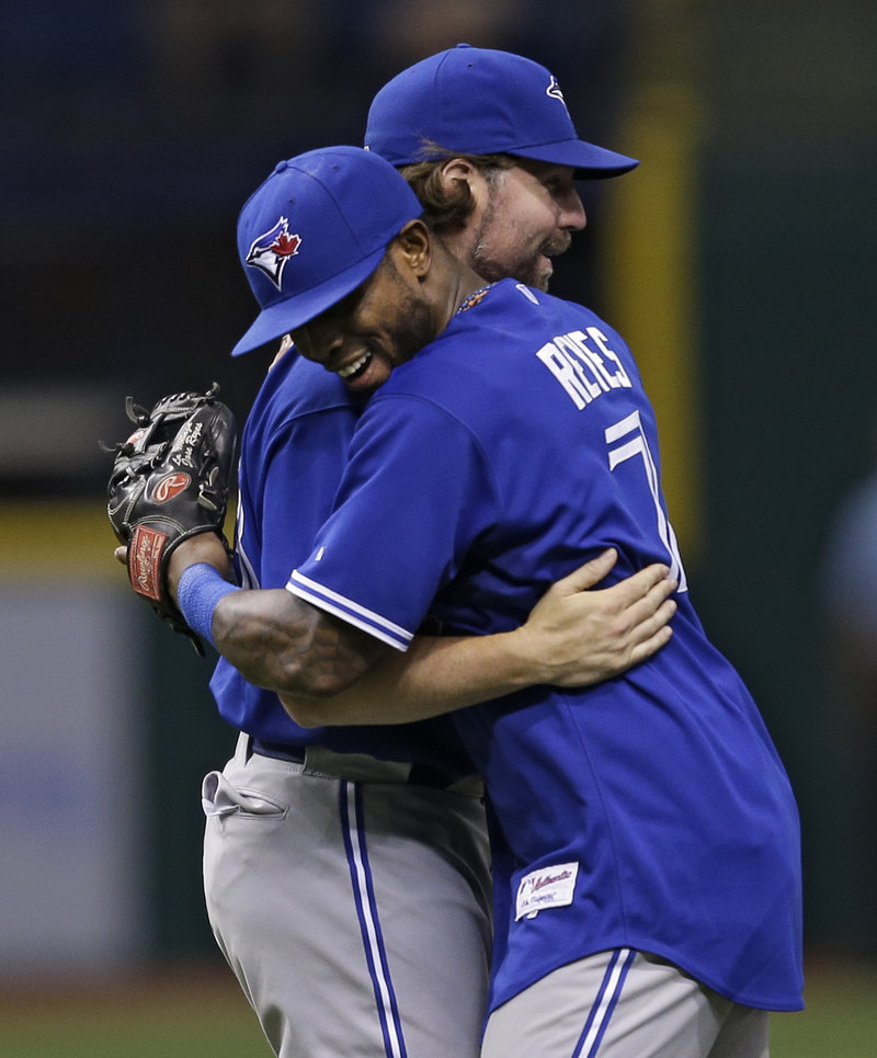 Toronto shortstop Jose Reyes (7) hugs starting pitcher R.A. Dickey after the Blue Jays defeated the host Rays, 3-0.