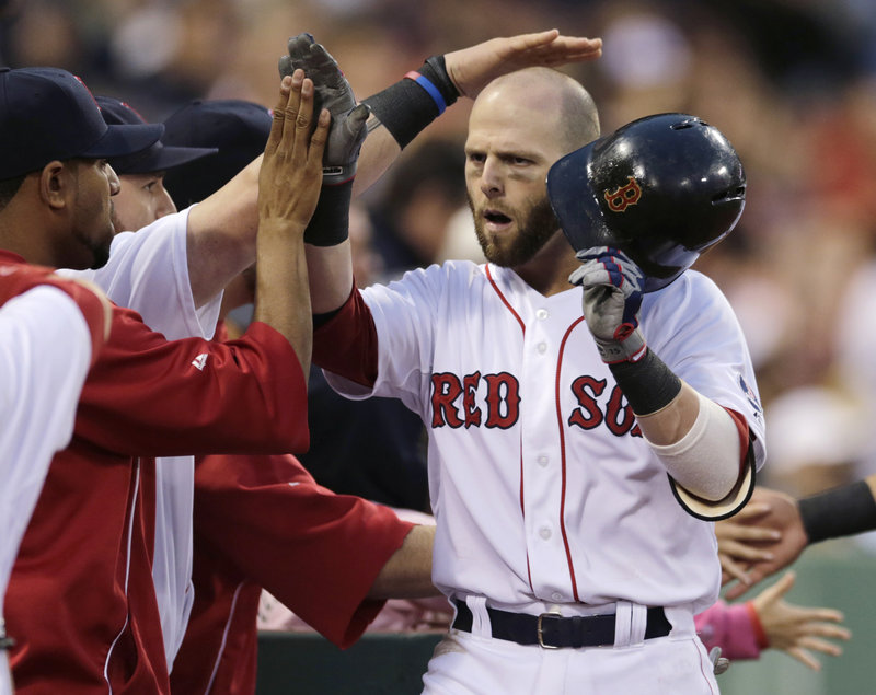 Dustin Pedroia heads to the dugout to a big welcome from his teammates after his two-run homer highlighted a seven-run second inning that gave the Red Sox all they would need to take Thursday’s opening game against the Toronto Blue Jays at Fenway Park.