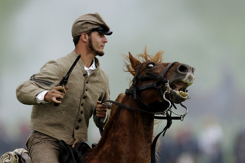 A mounted Confederate re-enactor takes part in a demonstration of a battle commemorating the 150th anniversary of the Battle of Gettysburg on Friday.