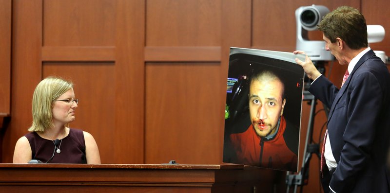 Mark O’Mara, George Zimmerman’s attorney, shows a photo of Zimmerman taken the night that Trayvon Martin was fatally shot, to physician’s assistant Lindzee Folgate during her testimony Friday in Sanford, Fla.