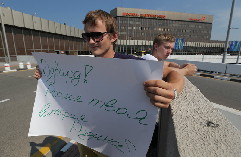 A supporter of National Security Agency leaker Edward Snowden holds a poster Friday outside Sheremetyevo airport in Moscow, where Snowden is believed to remain at the transit zone. The poster reads: “Edward! Russia is your second Motherland!”