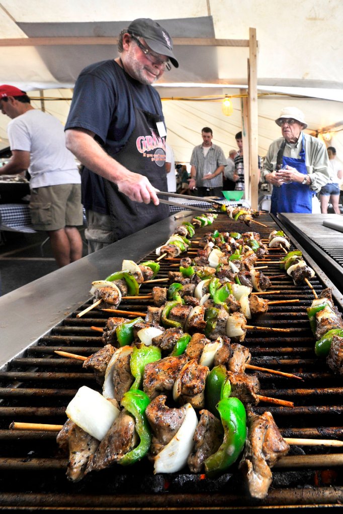 Byron Neal grills lamb souvlaki with help from Christopher Makrides, right, Saturday at the Greek Food Festival held at the Holy Trinity Greek Orthodox Church in Portland.
