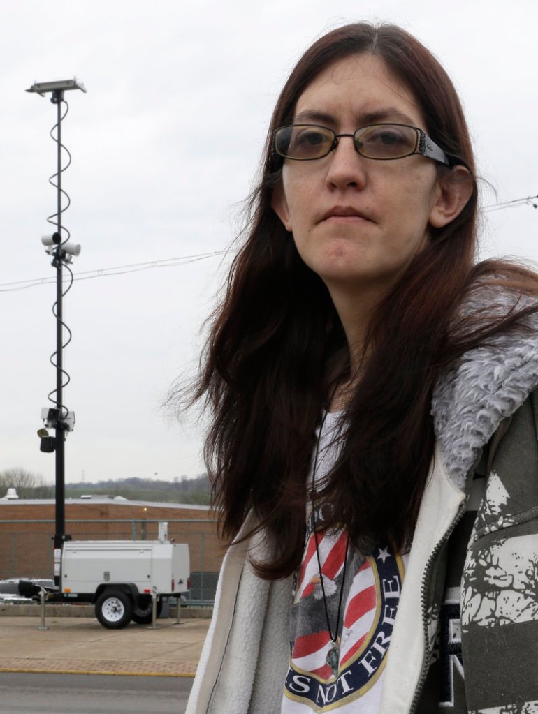 Holly Calhoun stands in front of a tower of speed cameras located near the Elmwood Quick Mart she manages in Elmwood Place, Ohio. Calhoun suspects government greed led to installation of the cameras in her village.