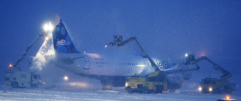 In this January 2012 file photo, a JetBlue plane gets de-iced prior to taking off at the Portland International Jetport. The city will receive $1.4 million for new snow-removal equipment from the FAA.