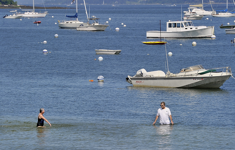 A couple cools off at the Falmouth Town Landing near Casco Terrace as heat bears down on the area Friday.