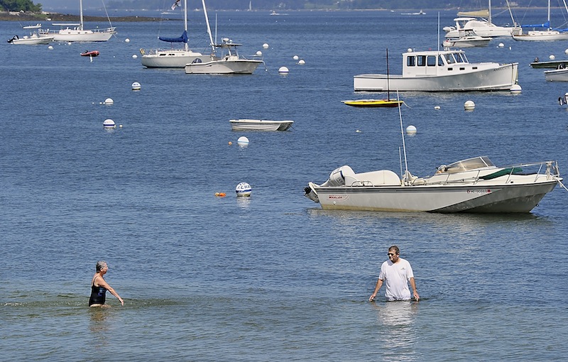 A couple enjoys the cool water off Falmouth's Town Landing near Casco Terrace Friday.
