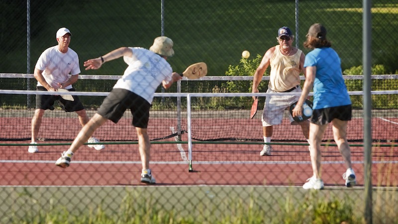 Teams of doubles compete during a pickleball match at Sunset Ridge Golf Course in Westbrook on Friday, July 5, 2013. Pickleball is a game similar to tennis, played with oversized ping pong paddles and a plastic ball like a whiffleball on a small tennis court with a 34-inch net.