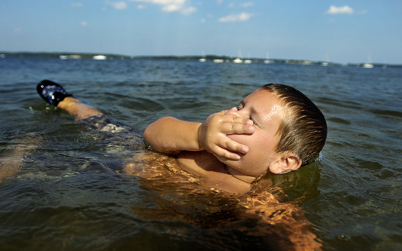 Brice Lyon, 9, of Westbrook, prepares to go under the water at East End Beach in Portland on Friday as he and his sister, Brooke Lyon-Dame, 5, and their mother, Stephanie Lyon, tried to cool off as a heat wave descended on southern Maine.