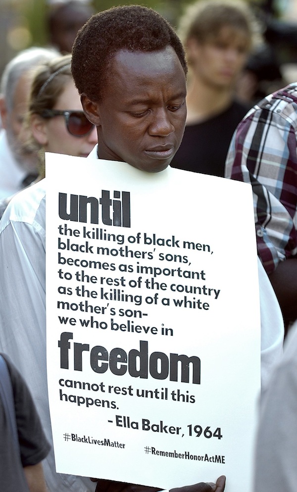 Lado Lodoka of Portland holds a sign while observing a moment of peace for Trayvon Martin at a rally in Monument Square Monday, July 22, 2013,