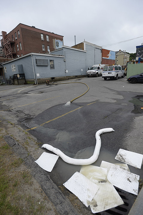 Water is pumped from a building after a water main break on Congress Street in Portland on Monday.