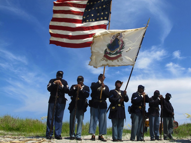 Black re-enactors in a color guard pray on Morris Island near Charleston, S.C., on Thursday, July 18, 2013 during a observance of the 150th anniversary of the charge of the black 54th Massachusetts Volunteer Infantry in a fight commemorated in the film "Glory." (AP Photo/Bruce Smith)