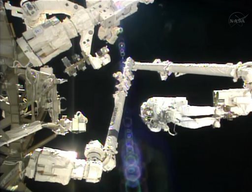 In this image made from video provided by NASA, Italian astronaut Luca Parmitano stands on the end of a robotic arm during a spacewalk outside the International Space Station on Tuesday, July 9, 2013.