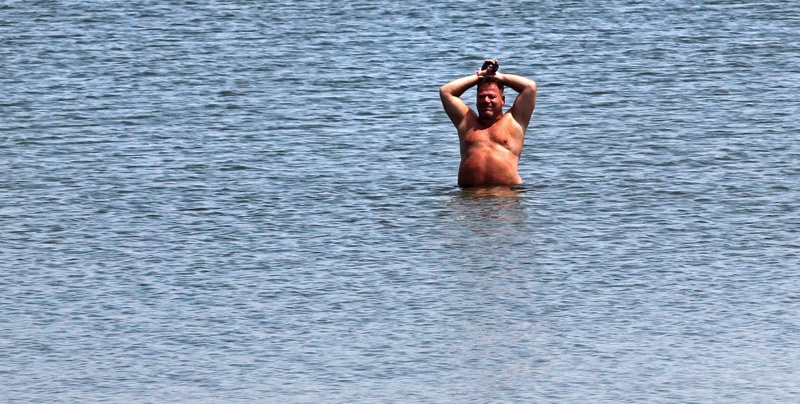 A man cools off on the shore of Castle Island in the South Boston neighborhood Wednesday. Temperatures in the Boston area reached the 90s, extending a heat wave.