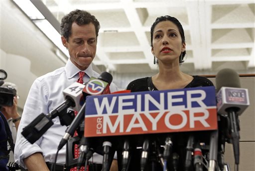 New York mayoral candidate Anthony Weiner, left, listens as his wife, Huma Abedin, speaks during a news conference at the Gay Men's Health Crisis headquarters on Tuesday in New York.