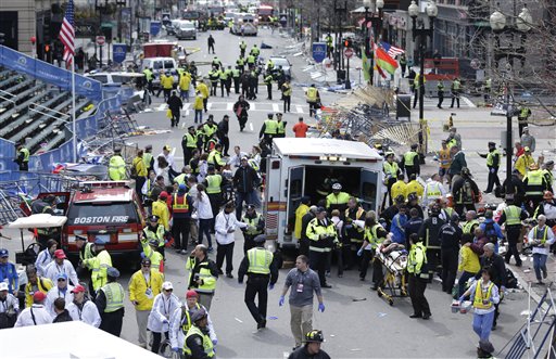 Medical workers aid injured people at the finish line of the Boston Marathon following explosions on April 15, 2013.
