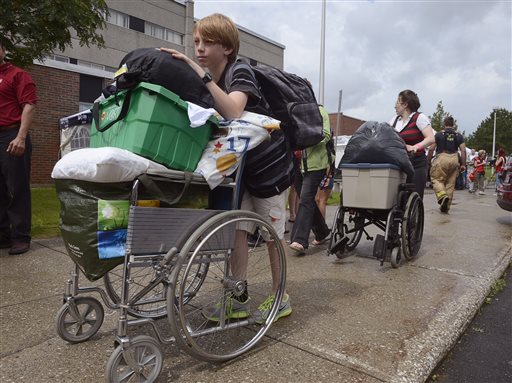 Evacuees Alexys Jacques, left, and his mother Lyne Boulanger leave an evacuation center to head back home after the evacuation order was reduced to a smaller perimeter, in Lac-Megantic, Quebec, on Tuesday. Officials said that 1,200 out of about 2,000 evacuees will be able to go back to their homes.