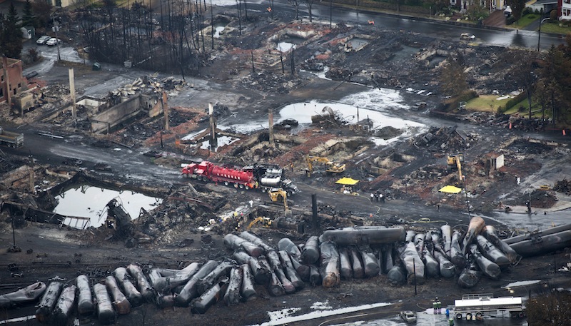 In a July 9, 2013 file photo workers comb through debris after a run away oil train derailed July 6, 2013 causing explosions, fire and destoying parts of Lac-Megantic, Quebec. Canadian transportation authorities banned one-man crews for trains with dangerous goods Tuesday, July 23, 2013, responding to calls for tougher regulations after the oil train derailment in Quebec killed 47 people. (AP Photo/The Canadian Press, Paul Chiasson) Canada
