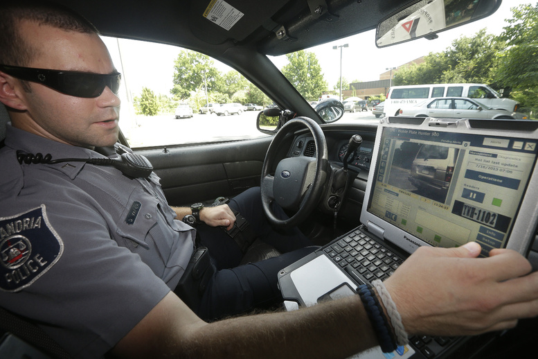 Officer Dennis Vafier of the Alexandria Police Department uses a laptop in his squad car to scan vehicle license plates during his patrols Tuesday in Alexandria, Va.