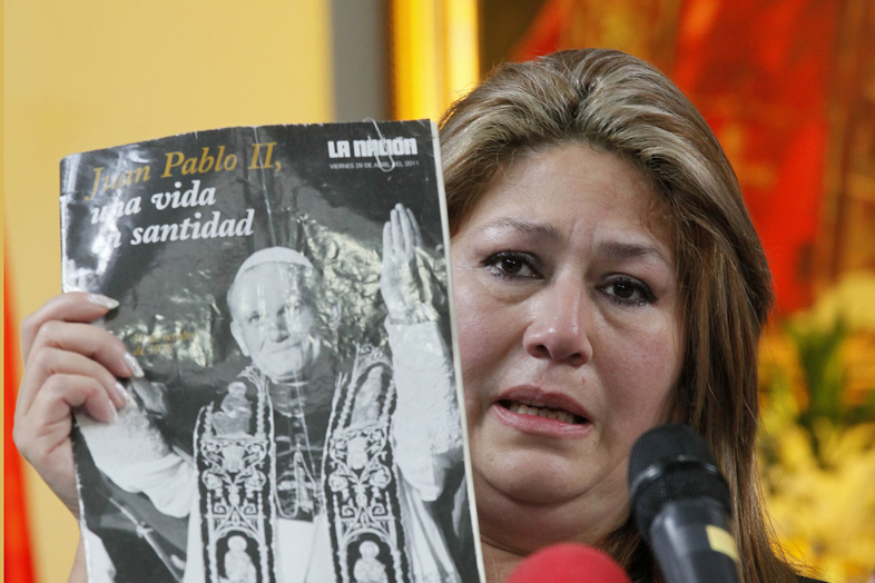 Floribeth Mora of Costa Rica holds up a magazine featuring Pope John Paul II on the cover as she gives her account of a miracle attributed to the late pope, during a news conference in San Jose, Costa Rica, on Friday.