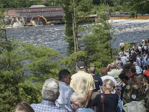 Hundreds of people watch the ceremonial breaching of the Veazie Dam from across the Penobscot River in Eddington Monday. Restoring Atlantic Salmon to the Penobscot River by the breaching of the Veazie Dam has been the collaborative effort of the Penobscot Indian Nation, seven conservation groups and state and federal agencies.
