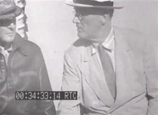 This image from an eight-second film clip provided by the National Archives shows President Franklin Delano Roosevelt, right, aboard the U.S.S. Baltimore in Pearl Harbor in July 1944, depicting a secret not revealed to the public until after his death. Person at left is unidentified.