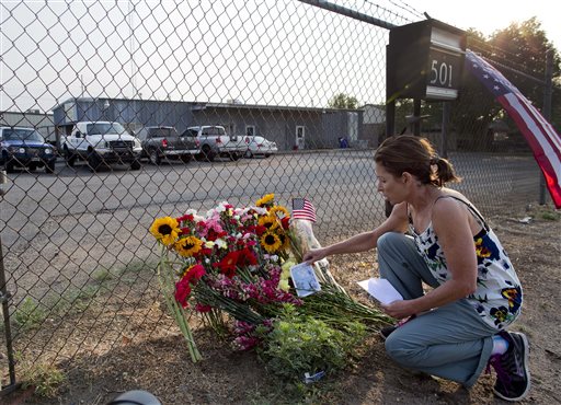 Toby Schultz lays flowers at the gate of the Granite Mountain Hot Shot Crew fire station, Monday in Prescott, Ariz. An out-of-control blaze overtook the elite group of firefighters trained to battle the fiercest wildfires, killing 19 members as they tried to protect themselves from the flames under fire-resistant shields.