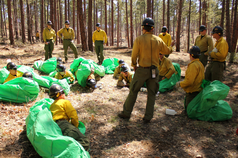 Phillip Maldonado, a squad leader with the Granite Mountain Hotshots, trains crew members on setting up emergency fire shelters last year. On Sunday, June 30, 2013, 19 members of the Prescott, Ariz.-based crew were killed in a wildfire. Arizona Wildfires