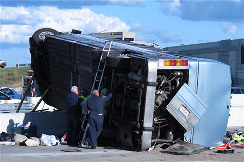 Indiana State Police investigators inspect the underside of a bus that crashed Saturday on the north side of Indianapolis while carrying teenagers returning from a summer camp in Michigan. Three people were killed and 26 others were taken to local hospitals.