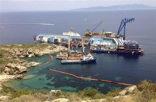 The Costa Concordia cruise ship lies on its side in the waters of the Tuscan island of Giglio, Italy, on Monday. The luxury cruise ship ran aground off the coast of Tuscany on Jan 13, 2012, sending water pouring in through a 160-foot gash in the hull and forcing the evacuation of some 4,200 people from the listing vessel.