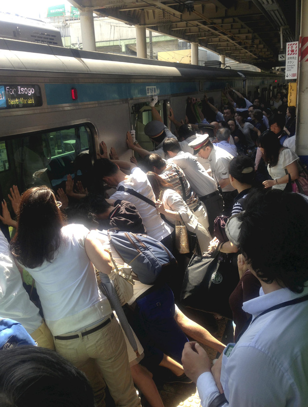Train passengers and railway staff push a train car in their effort to rescue a woman who fell and got stuck between the car and the platform while getting off at Japan Railway Minami Urawa Station in Saitama, near Tokyo, Monday morning. A Yomiuri Shimbun photographer who happened to be there said there was a big applause when the woman, who fell to her waist, was safely rescued without any serious injuries. About 40 people helped the staff who were pushing the car after hearing an announcement that a passenger has been trapped.