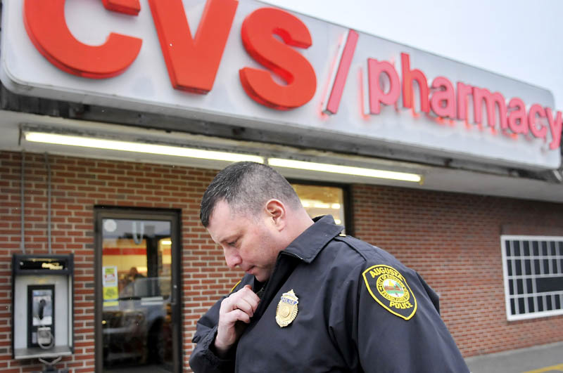 In this November 2012 file photo, Augusta Police Dept. Lt. Christopher Massey speaks on the radio moments after arriving at the CVS Pharmacy in response to a robbery. The number of pharmacy robberies in Maine spiked from 24 in 2011 to 58 in 2012