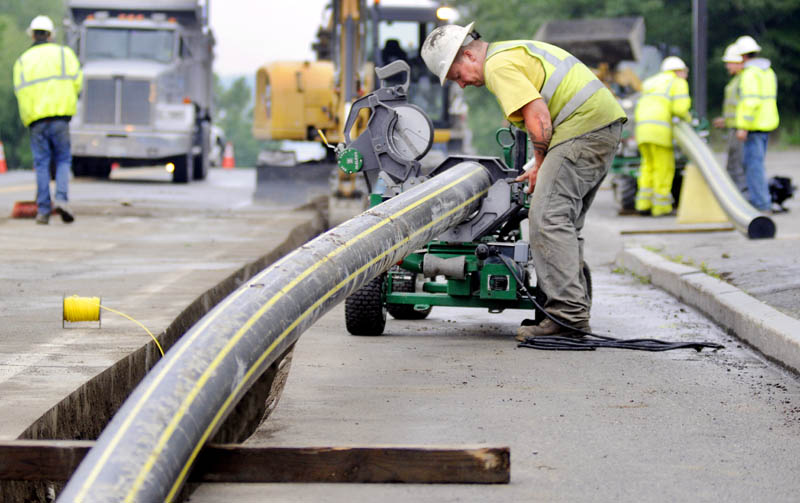 In this July 2 file photo, workers lay gas pipes in Augusta for Maine Natural Gas. In an open letter to the Augusta City Council on Tuesday, Maine Natural Gas announced it is withdrawing its proposal to provide city property, including schools, with gas and will focus on expanding its system throughout the city.