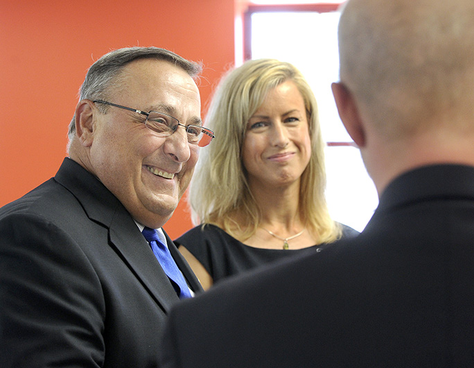 Gov. Paul LePage shares a light moment with Allison Crean Davis, vice chairwoman of the Baxter Academy board, and others during the Maine Heritage Policy Center luncheon at the charter school in Portland on Wednesday.