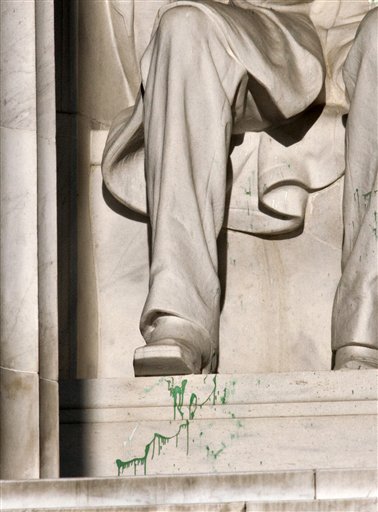 Splattered green paint is seen on the right shoe area of the Abraham Lincoln statue at the Lincoln Memorial in Washington. Police say the apparent vandalism was discovered early Friday morning. No words, letters or symbols were visible in the paint.