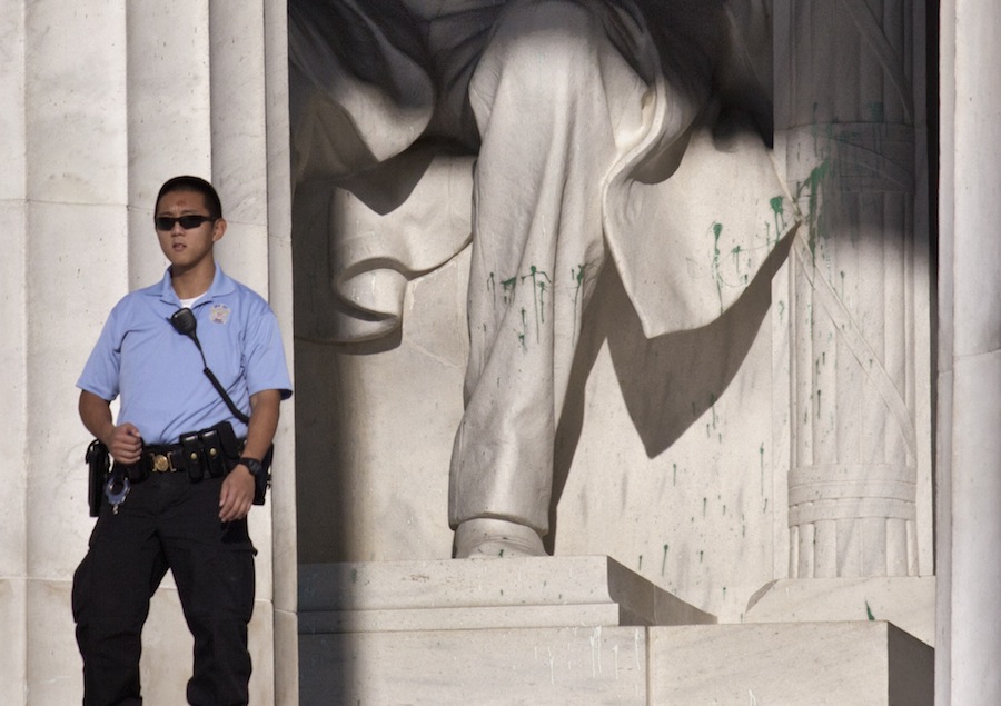 A U.S. Park Police officer stands guard next to the statue of Abraham Lincoln at the memorial in Washington, Friday, July 26, 2013, after the memorial was closed to visitors after someone splattered green paint on the statue and the floor area. Police say the apparent vandalism was discovered early Friday morning. No words, letters or symbols were visible in the paint. (AP Photo/J. Scott Applewhite)