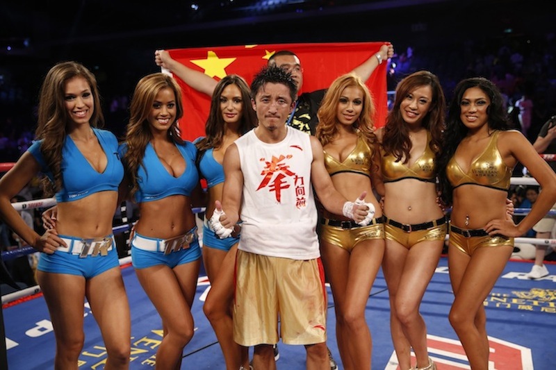 Chinese boxer Zou Shiming poses with ring girls before the Flyweight Bout match against Mexico's Jesus Ortega at the Cotai Arena in Venetian Macao in Macau Saturday July 27, 2013.A Chinese fighter’s victory at a Macau showdown brings the world’s top casino market a step closer to challenging Las Vegas for dominance of another Sin City staple: big-time boxing matches. Macau, which long ago eclipsed Vegas as the world's top gambling city, is now looking to add to its allure by holding the kind of boxing bouts that Las Vegas is known for. (AP Photo/Dennis Ho)